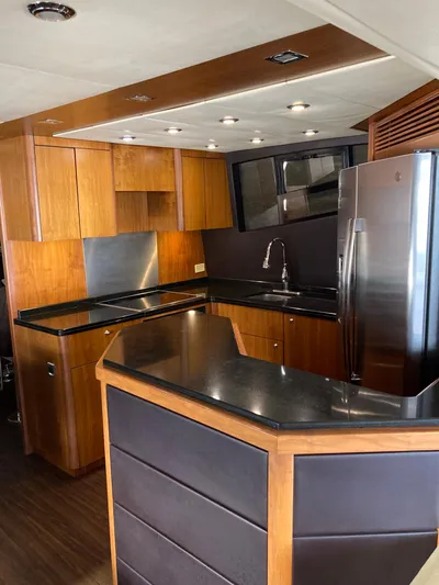 La Chaparrita Yacht Photos Pics Modern kitchen interior of 2011 Sunseeker Manhattan 70 yacht with wooden cabinets and stainless steel appliances.