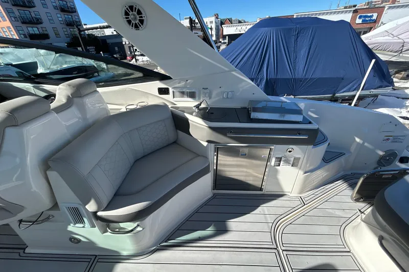  Yacht Photos Pics 2021 Sea Ray Sundancer 320 interior with seating and kitchenette, docked outdoors.