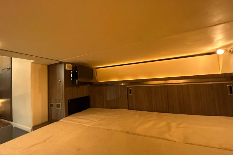  Yacht Photos Pics 2021 Sea Ray Sundancer 320 cabin interior with cozy lighting and wood paneling.