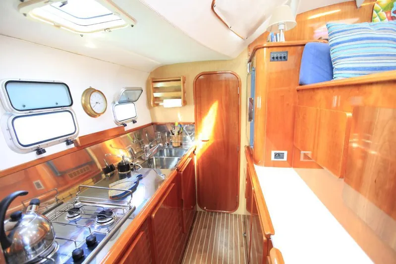Osina Yacht Photos Pics Luxurious galley kitchen in 2000 Privilege 37 yacht with wooden cabinetry and stainless steel appliances.
