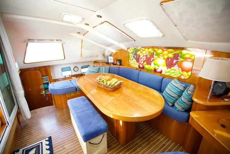 Osina Yacht Photos Pics Luxurious interior of 2000 Privilege 37 yacht with wooden table and blue seating.