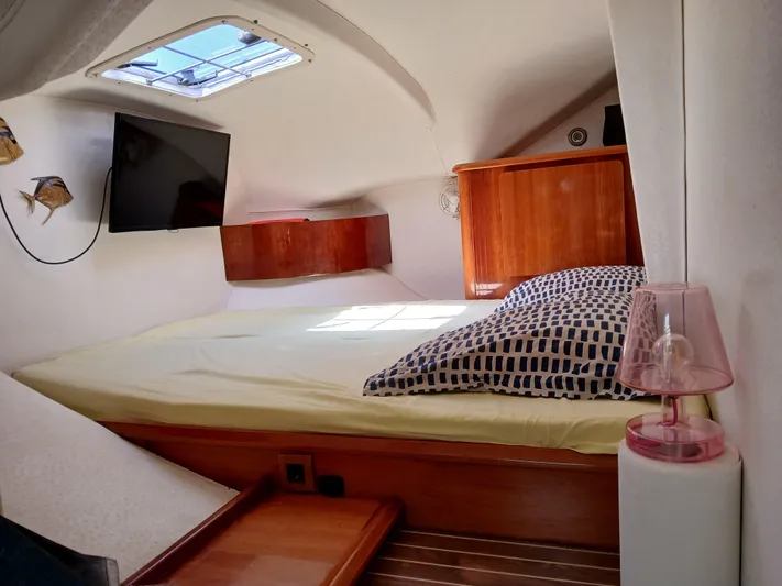 Osina Yacht Photos Pics Cozy cabin interior of 2000 Privilege 37 yacht with bed, TV, and wooden accents.