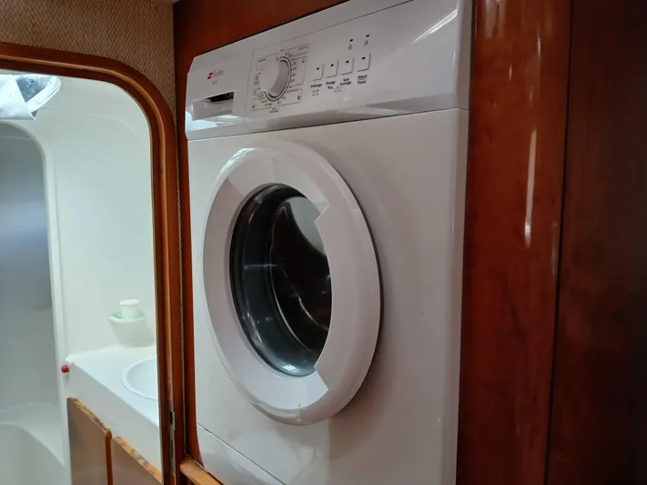 Osina Yacht Photos Pics Washing machine inside a 2000 Privilege 37 yacht, wooden cabinetry, compact design.