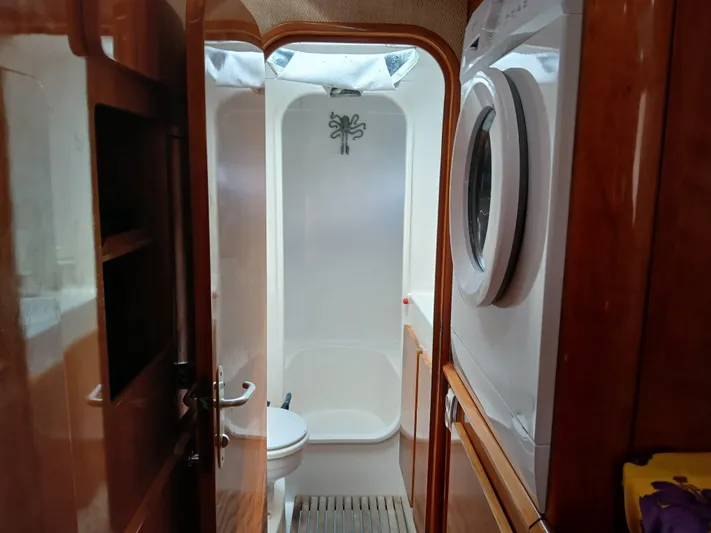 Osina Yacht Photos Pics Bathroom interior of 2000 Privilege 37 yacht with washing machine and wooden accents.
