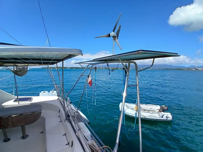 Osina Yacht Photos Pics Sailing catamaran Privilege 37 with solar panels and wind turbine on calm blue sea.