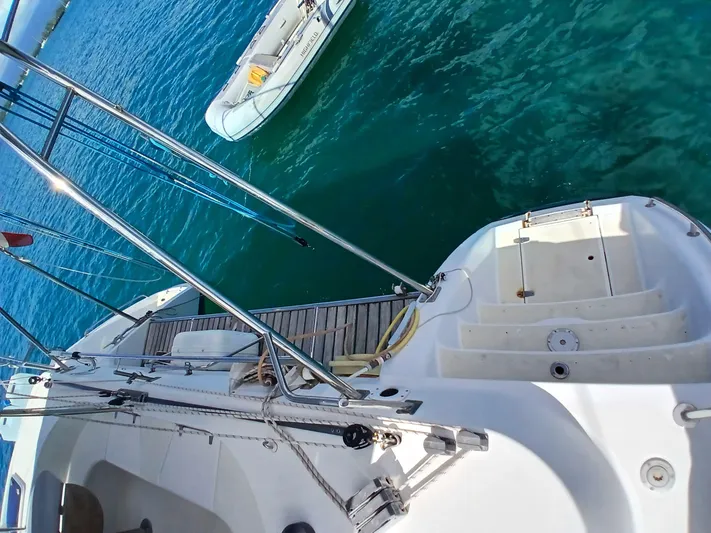 Osina Yacht Photos Pics Sailing yacht Privilege 37, 2000 model, docked with clear blue water and small boat nearby.