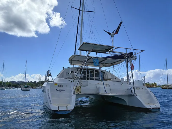 Osina Yacht Photos Pics Catamaran Privilege 37, 2000 model, anchored in sunny marina with clear blue skies.
