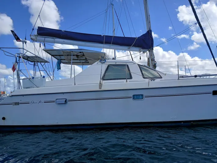 Osina Yacht Photos Pics Sailing catamaran Privilege 37, 2000 model, on water under blue sky.