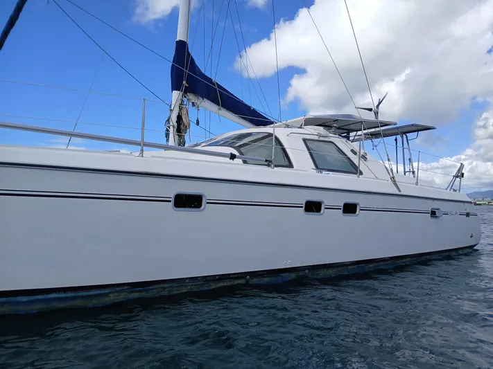 Osina Yacht Photos Pics Sailing catamaran Privilege 37, 2000 model, on calm blue waters under a clear sky.