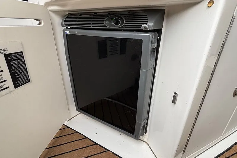  Yacht Photos Pics Compact refrigerator in 2005 Sea Ray 340 Sundancer boat, open cabinet, white interior.