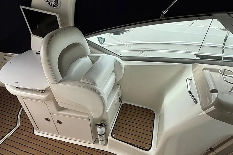  Yacht Photos Pics 2005 Sea Ray 340 Sundancer helm with white captain's chair and wooden deck.