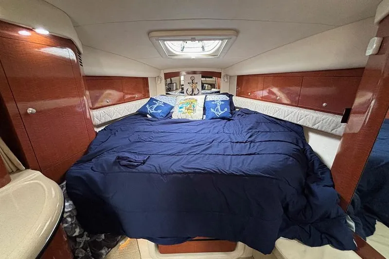  Yacht Photos Pics Luxurious cabin interior of 2005 Sea Ray 340 Sundancer with cozy bedding and wooden accents.