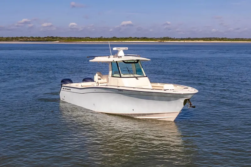  Yacht Photos Pics 2022 Grady-White Canyon 336 boat on calm water, clear sky background.