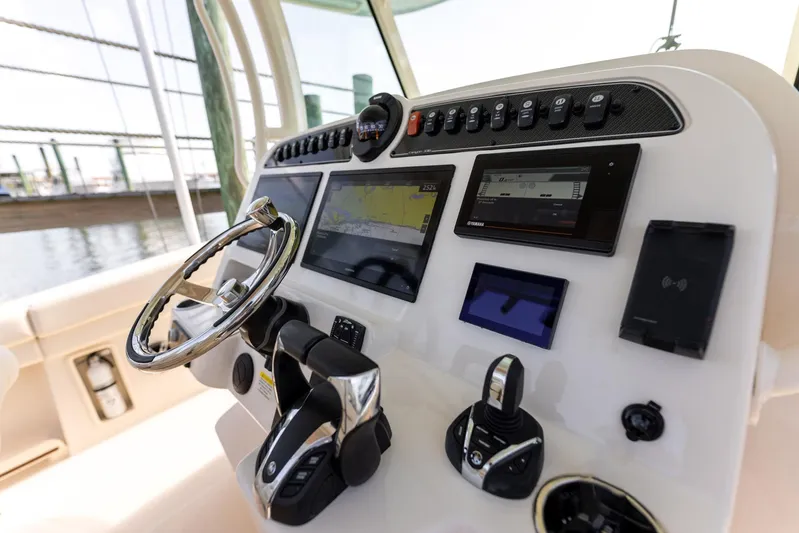  Yacht Photos Pics Control panel of 2022 Grady-White Canyon 336 boat with steering wheel and navigation screens.