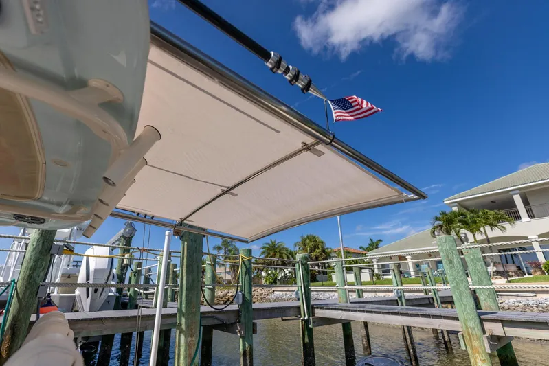  Yacht Photos Pics 2022 Grady-White Canyon 336 boat docked, featuring a sunshade and American flag.