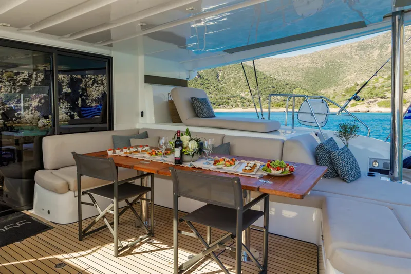  Yacht Photos Pics Luxurious 2023 Lagoon 55 yacht with elegant dining setup and scenic ocean view.