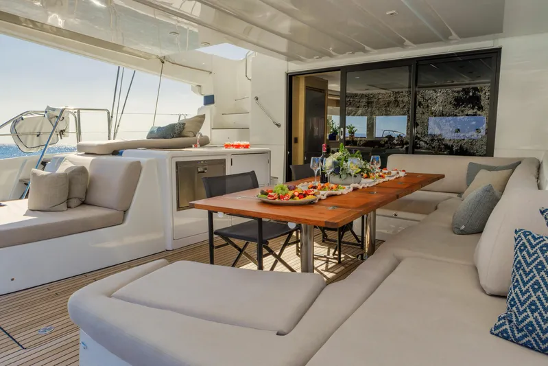  Yacht Photos Pics Luxurious 2023 Lagoon 55 yacht interior with elegant dining setup and plush seating.