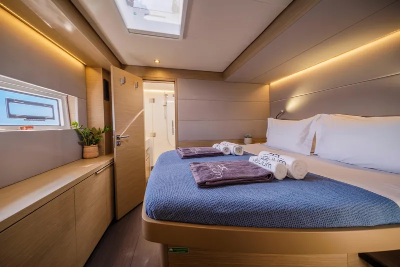  Yacht Photos Pics Luxurious cabin interior of 2023 Lagoon 55 yacht with modern design and cozy bedding.