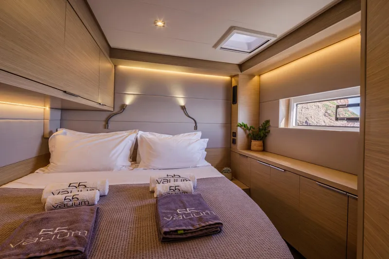  Yacht Photos Pics Luxurious cabin interior of 2023 Lagoon 55 yacht with modern design and cozy bedding.
