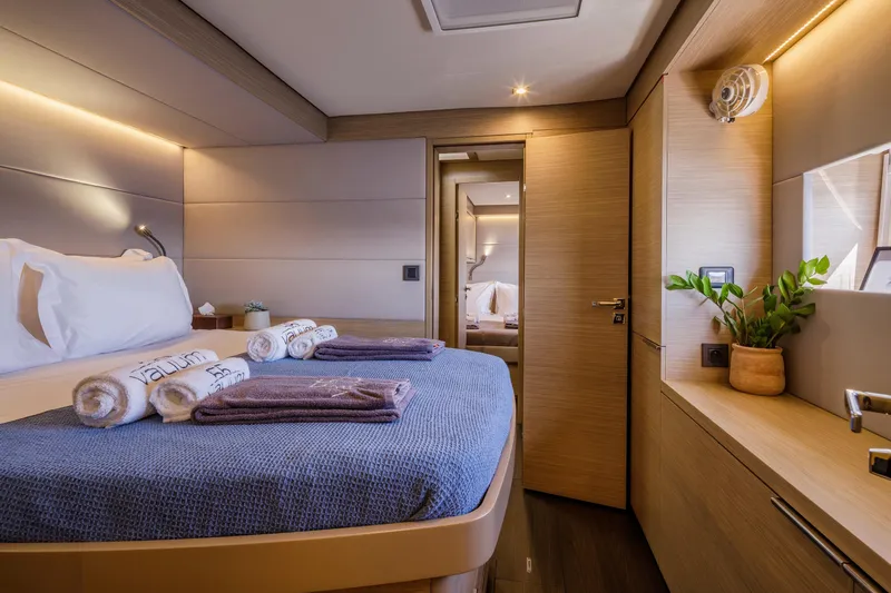  Yacht Photos Pics Luxurious cabin interior of 2023 Lagoon 55 yacht with modern decor and cozy bedding.