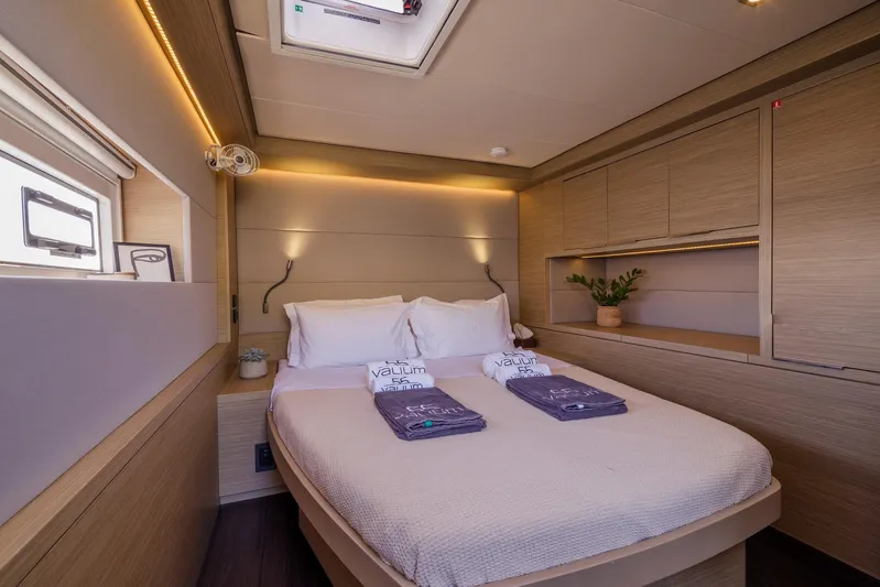  Yacht Photos Pics Luxurious bedroom interior of 2023 Lagoon 55 yacht, featuring modern design and cozy ambiance.