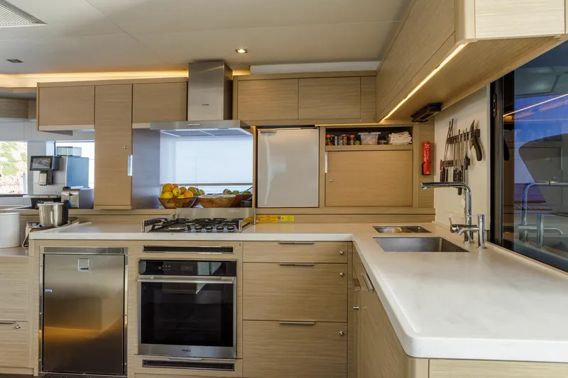  Yacht Photos Pics Modern kitchen interior on 2023 Lagoon 55 yacht, featuring sleek cabinetry and stainless steel appliances.