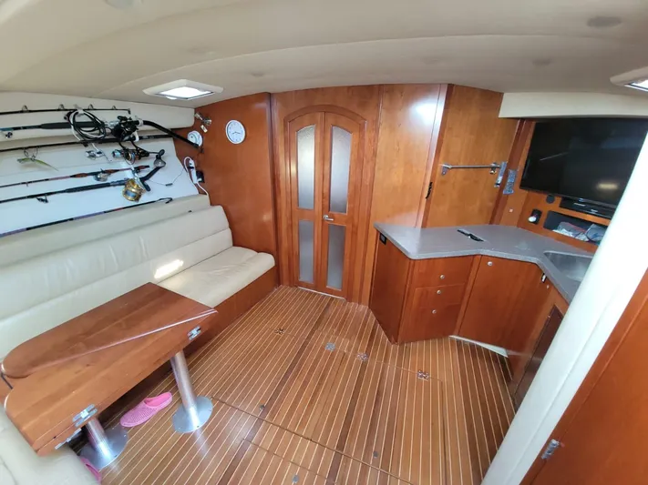  Yacht Photos Pics Interior of 2011 Rampage 41 Express boat with wooden flooring and fishing rods.