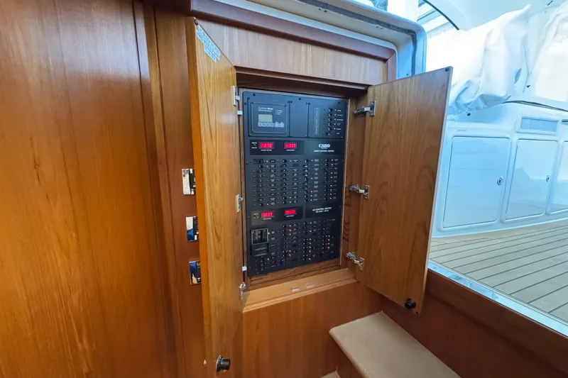 Regalo Yacht Photos Pics Electrical panel inside 2013 Cabo 44 Hardtop Express yacht, featuring wooden cabinetry.