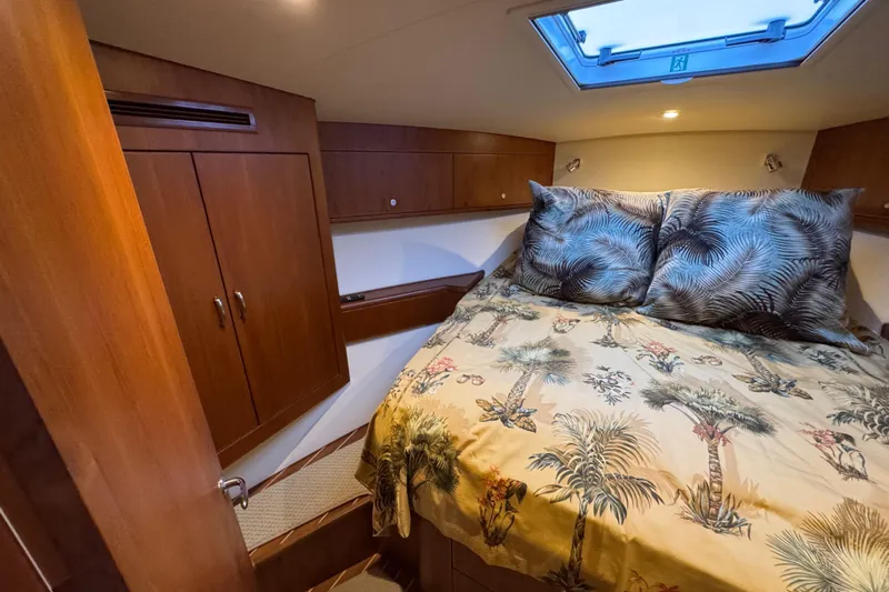 Regalo Yacht Photos Pics 2013 Cabo 44 Hardtop Express cabin with tropical bedding and wooden cabinetry.