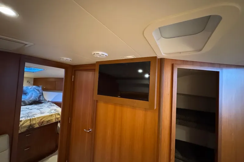 Regalo Yacht Photos Pics 2013 Cabo 44 Hardtop Express interior with TV, bed, and wooden cabinetry.
