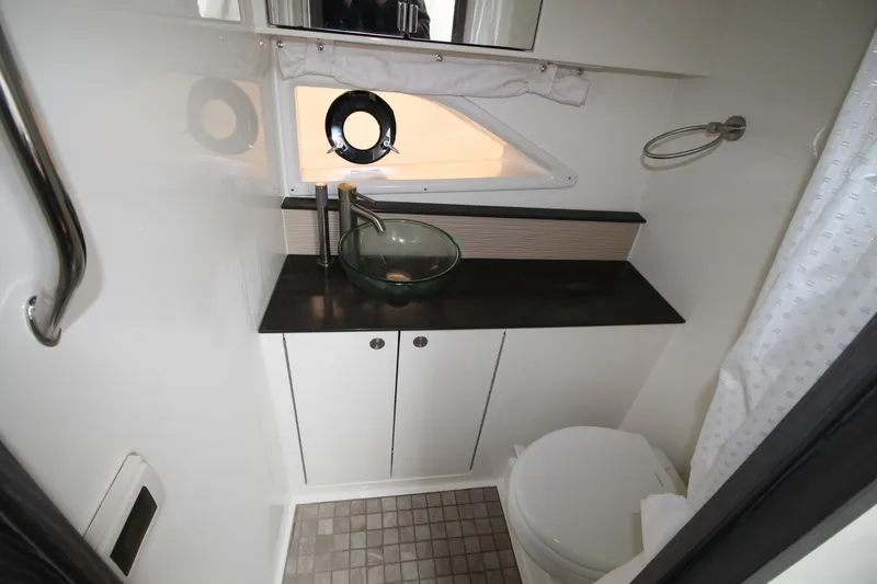  Yacht Photos Pics 2020 Sea Ray Sundancer 320 bathroom with modern sink, toilet, and porthole window.