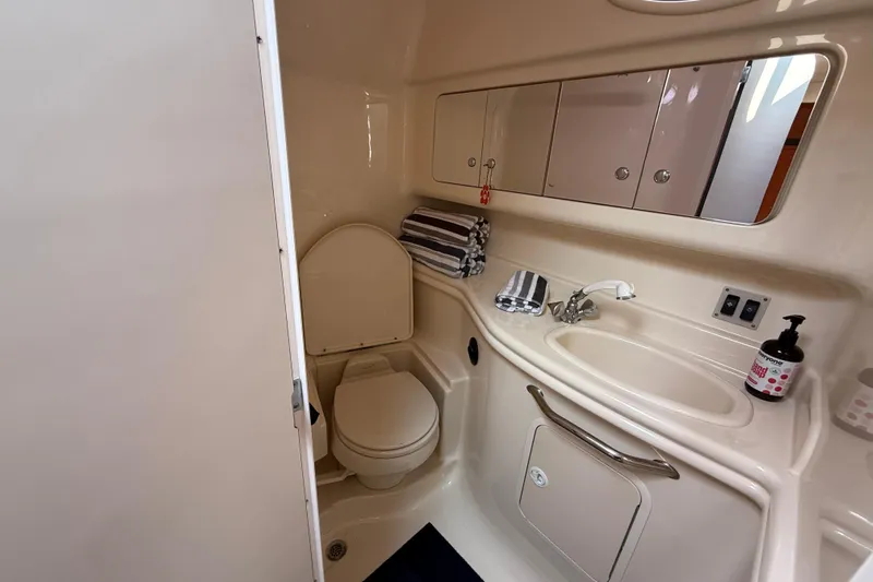  Yacht Photos Pics 2003 Sea Ray 340 Sundancer bathroom with sink, toilet, mirror, and storage cabinets.