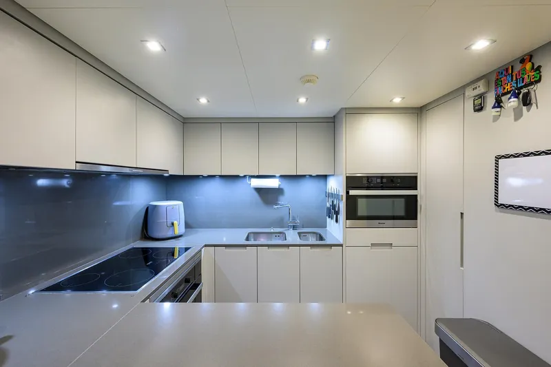 Phoenix Yacht Photos Pics Modern kitchen interior on 2019 Sanlorenzo SD112 yacht, featuring sleek cabinetry and appliances.