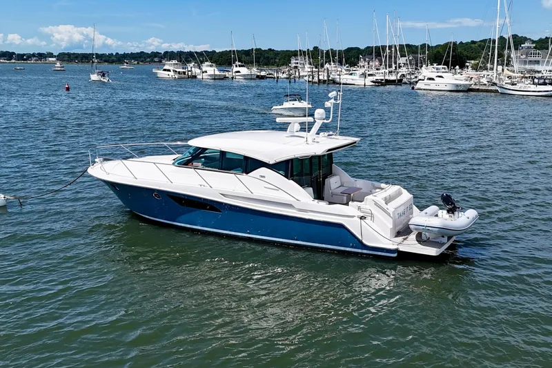  Yacht Photos Pics 2017 Tiara Yachts C44 Coupe in a marina, surrounded by other boats.