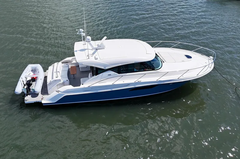  Yacht Photos Pics 2017 Tiara Yachts C44 Coupe on water, featuring sleek design and attached dinghy.