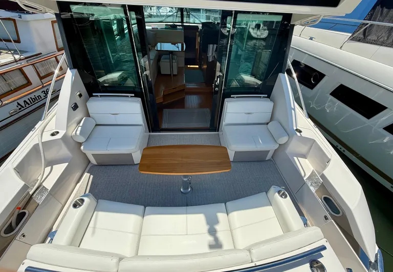  Yacht Photos Pics 2017 Tiara Yachts C44 Coupe cockpit with white seating and wooden table.