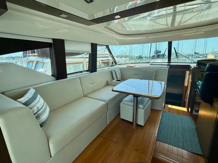  Yacht Photos Pics Luxurious interior of 2017 Tiara Yachts C44 Coupe with elegant seating and table.