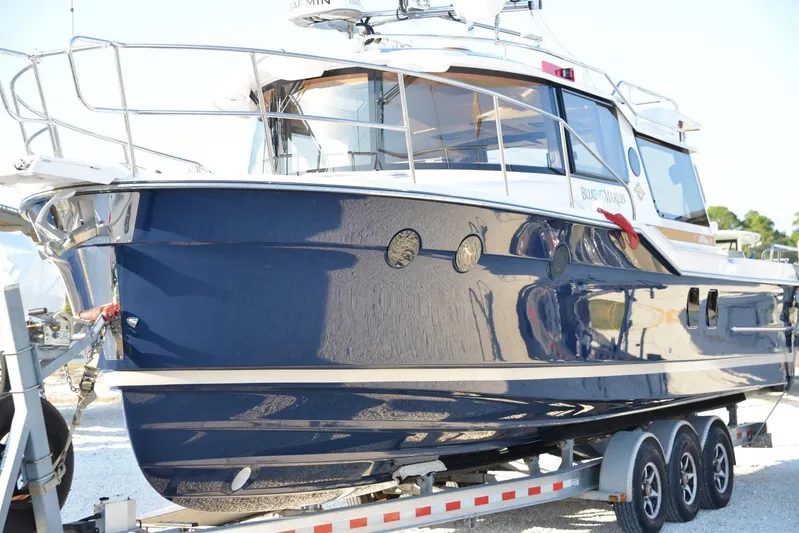  Yacht Photos Pics 2026 Ranger Tugs R-29 S boat on trailer, sleek blue exterior, docked outdoors.