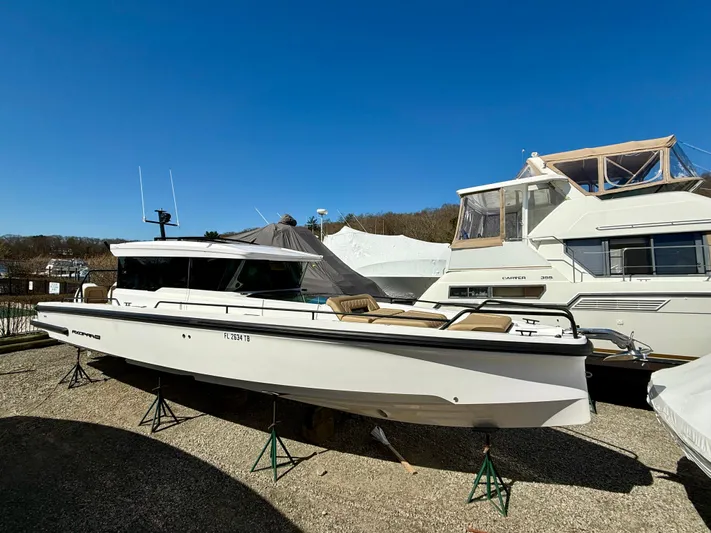  Yacht Photos Pics 2021 Axopar 37 boat on display, parked on stands under clear blue sky.