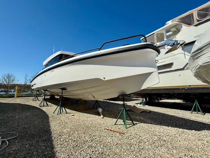  Yacht Photos Pics 2021 Axopar 37 boat on stands, displayed outdoors under clear blue sky.