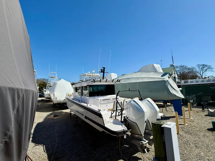  Yacht Photos Pics 2021 Axopar 37 boat in storage yard under clear blue sky.