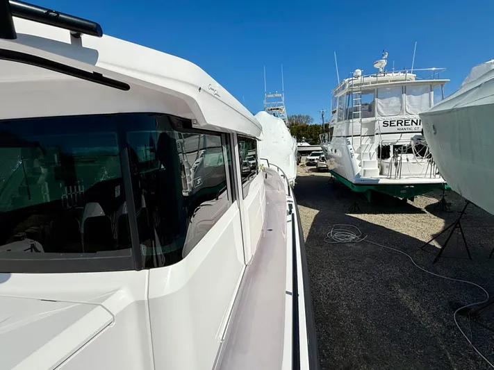  Yacht Photos Pics Axopar 37 boat, 2021 model, docked alongside other vessels under clear blue sky.