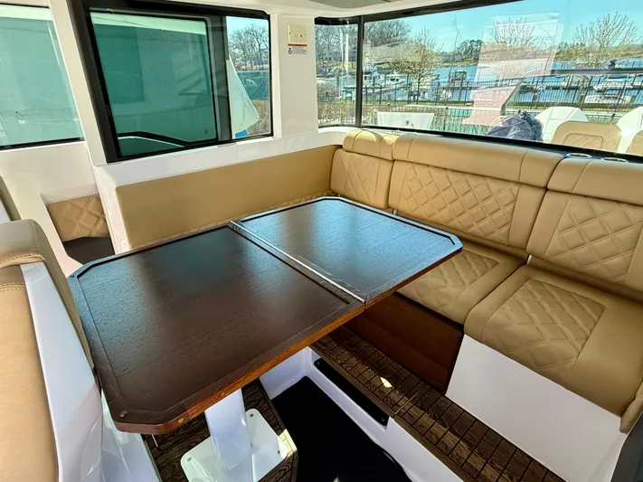  Yacht Photos Pics Interior of 2021 Axopar 37 boat with tan seating and wooden table.
