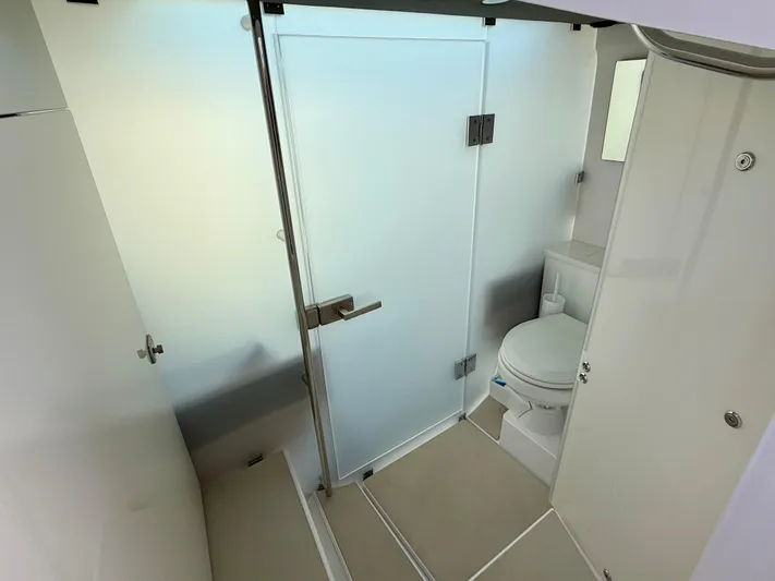  Yacht Photos Pics Modern bathroom interior on 2021 Axopar 37 boat, featuring a toilet and frosted glass door.