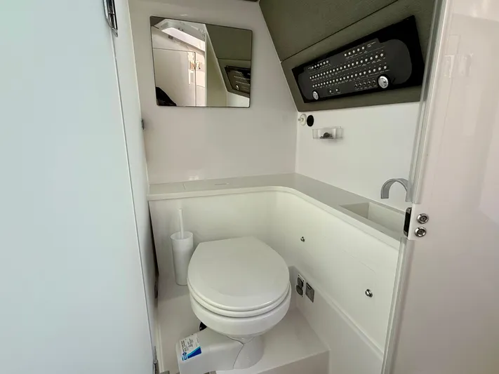  Yacht Photos Pics 2021 Axopar 37 boat bathroom with toilet, mirror, and modern fixtures.