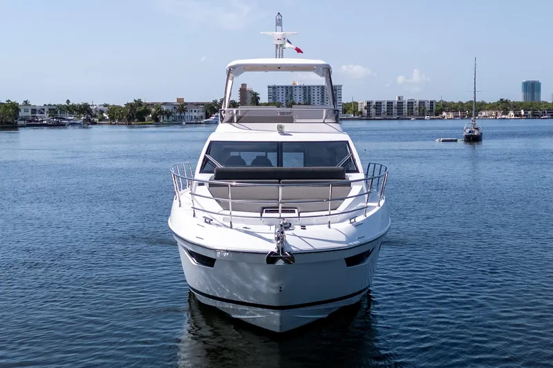 Andromeda Yacht Photos Pics 2023 Azimut Fly 50 yacht on calm water, cityscape in background.