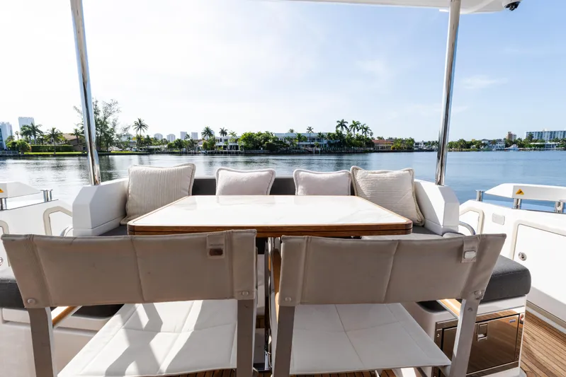 Andromeda Yacht Photos Pics 2023 Azimut Fly 50 yacht deck with dining area overlooking serene waterfront.