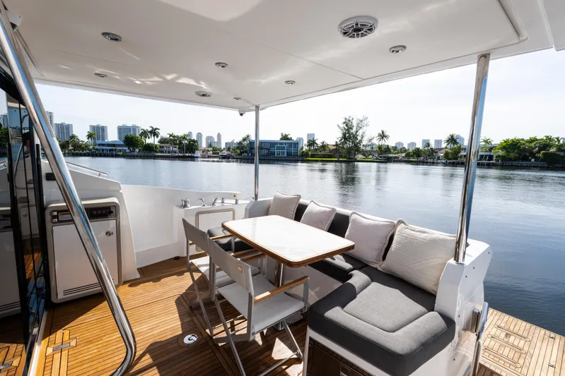 Andromeda Yacht Photos Pics Luxurious 2023 Azimut Fly 50 yacht deck with seating, table, and scenic waterfront view.