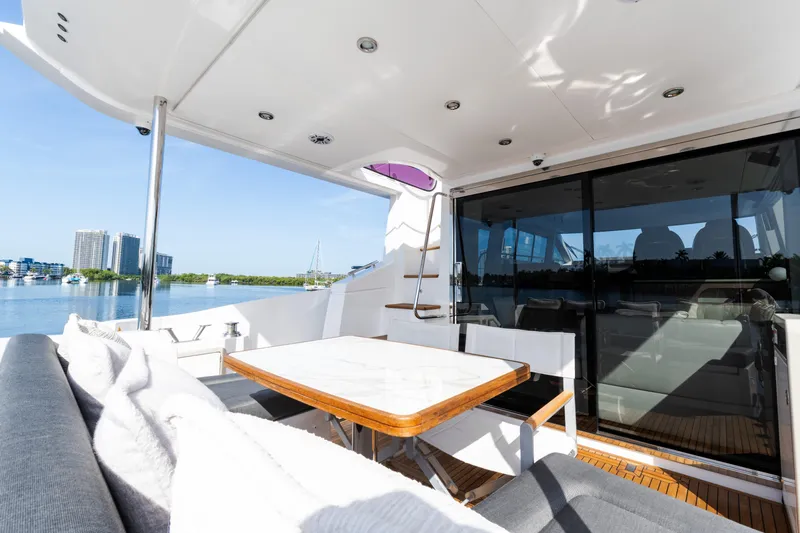 Andromeda Yacht Photos Pics Luxurious 2023 Azimut Fly 50 yacht deck with seating and scenic waterfront view.