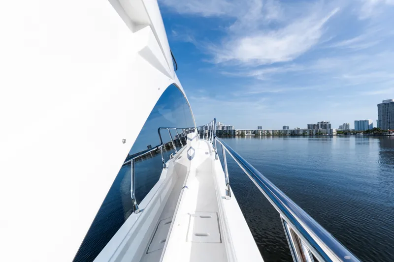 Andromeda Yacht Photos Pics 2023 Azimut Fly 50 yacht cruising on calm waters with city skyline.